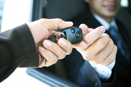 The car salesman and the key to the new owner.