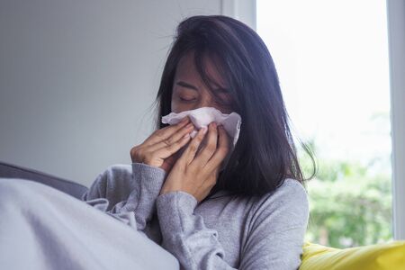 Asian women have high fever and runny nose. sick people conceptの写真素材
