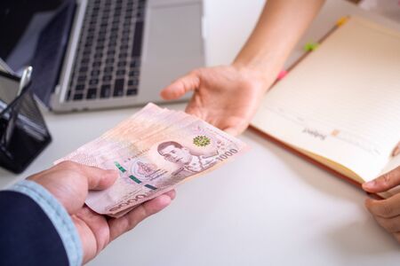 The boss pays the employees the salary is the compensation for the work they do.の写真素材