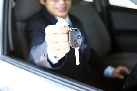 The car salesman and the key to the new owner.