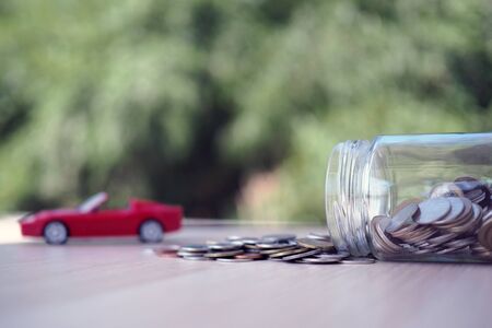 Coin jar and car model Represents the debt from buying a car. debt or save conceptの写真素材