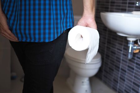 Men have abdominal pain holding toilet tissueの写真素材