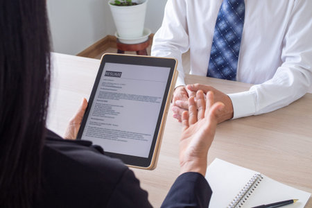 Businessmen open the resume for the applicant in an email via tablet during a job interview.