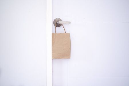 Online shopping and express delivery concept. Cardboard bags for food. Food bags hung in front of the house door. Transporting food and goods. fast and free delivery.  Internmentの写真素材