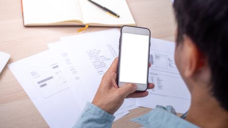 Men are using smartphone to pay bills online at home.の写真素材