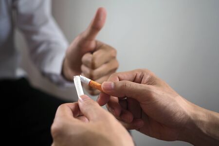 One hand broke the cigarette and had another thumbs up. The concept of smoking causes lung cancer. Just say noの写真素材