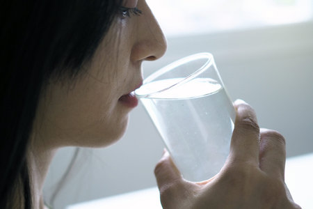 A beautiful Asian woman is happy to drink water. For good health and skin