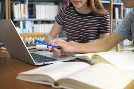 High school students or students are reading and studying. Use computers and books as a source of...