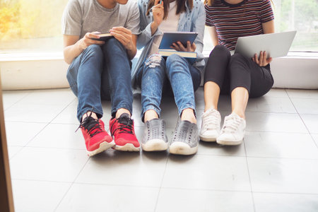 Student groups are viewing information in the tablet. Having a gesture of agreement and smiling,...