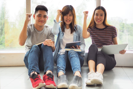 Student groups are viewing information in the tablet. Having a gesture of agreement and smiling,...