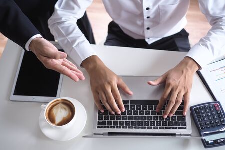 The human hand uses the keyboard by the notebook on the desk. Internet education and communication conceptsの写真素材