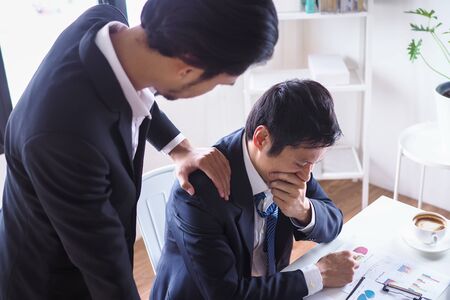 A business man to support and encourage a colleague who is working wrong until firedの写真素材