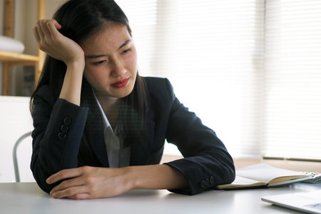 Asian businessmen have a headache that the office feels uncomfortable at work.