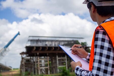 The inspectors or engineers are checking the work of the contractor team to build a bridge over the road.の写真素材