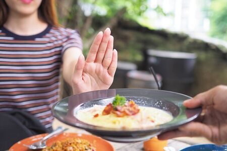 Women push dishes that are thought to be a mixture of fat trans fat. Lose weight do not eat flourの写真素材