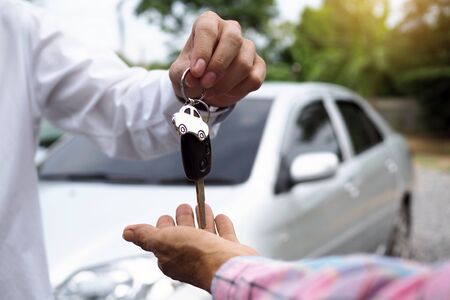 The car salesman and the key to the new owner.の写真素材