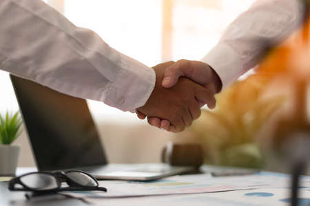 A close up of two business men holding hands, agreeing to work together, or congratulating each other. Business People Shaking Handsの写真素材