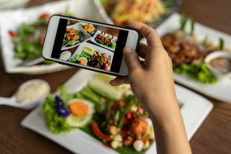 Woman take picture of a meal on the table after ordering food online to eat at home. Photography and use phone conceptsの写真素材