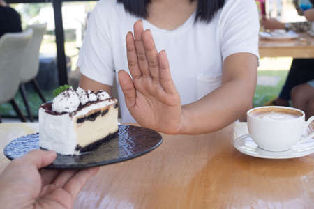 The women used to push the cake plate with the people.  Do not eat desserts for weight loss.の写真素材