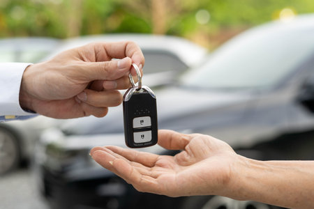 selling car, car sale, deal concept The dealer gives the car keys to the new owner or renter with an...