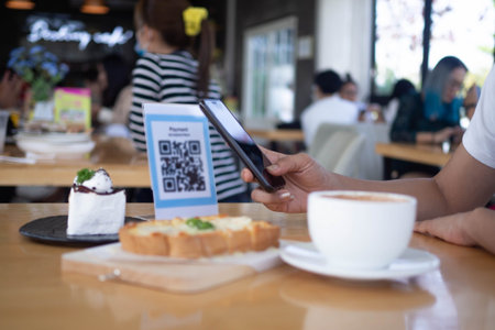 hands are using  the phone to scan the qr code to select food menu. Scan to get discounts or pay for...