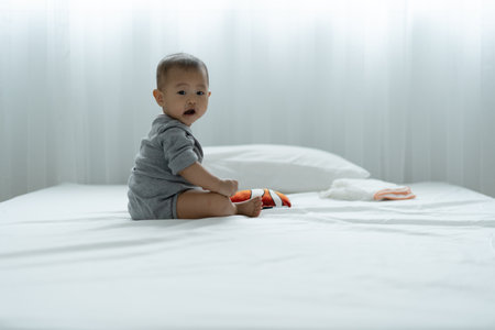 Asian baby playing toys and wooden puzzles on the bed. baby are happy to be together. activities to promote the development of the baby's age. Asia childranâs day concept.の写真素材