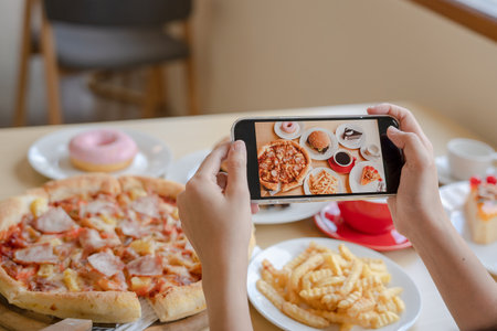 italian food. The restaurant owner takes a picture of the food on the table with a smartphone to post on a website. Online food delivery and ordering serviceの写真素材