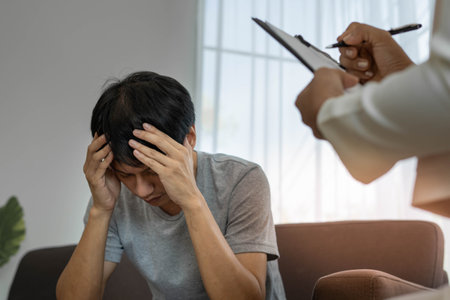 An Asian male patient speaks to a psychiatrist for a mental or physical health consultation in a mental health center or hospital.の写真素材