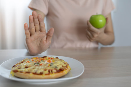 Diet and lose weight concept. Woman reject to eat pizza and choose eat green apple for good health...