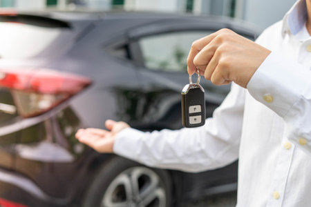 selling car, car sale, deal concept The dealer gives the car keys to the new owner or renter with an...