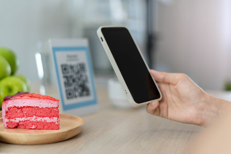 Women use phone to scan qr code to select food menu and collect points. Scan to get discounts or pay for food. The concept of using a phone to transfer money or paying money online without cash.の写真素材