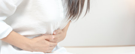 stomach ache. Asian women have abdominal pain, indigestion, gastritis, menstrual cramps, flatulence, diarrhea, distention, colon cancer, belly inflammation problem, suffer food poisoning, abdomeの写真素材