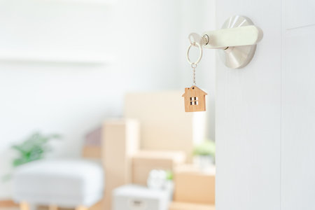Moving house, relocation. The key was inserted into the door of the new house, inside the room was a cardboard box containing personal belongings and furniture. move in the apartment or condominiumの写真素材