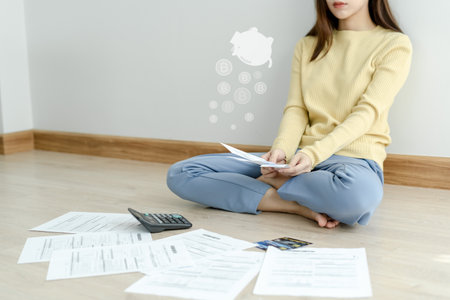 Stressed and headache asian woman with large bills or invoices no money to pay to expenses and credit card debt. shortage, Financial problems, mortgage, loan, bankruptcy, bankrupt, poor, empty walletの写真素材