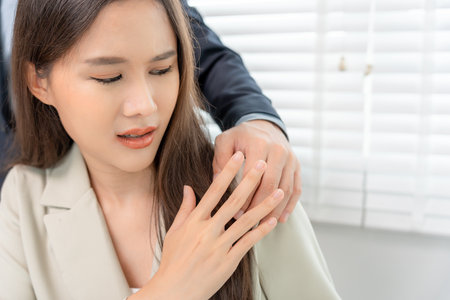 businessman sexually harassed a female colleague by touch her shoulder. Sexual harassment in office. Women feel anxious and stressed from being harassed. molest, assault, inappropriate, discriminationの写真素材