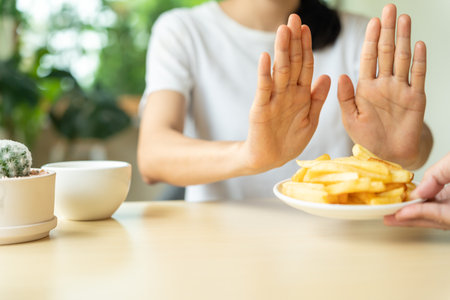 Beauty slim female body confuse french fries. Woman in restaurant achieves weight loss goal for healthy life, crazy about thinness, thin waist, nutritionist. Diet, body shape.の写真素材