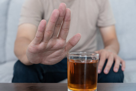 man refuses say no and avoid to drink an alcohol whiskey , stopping hand sign male, alcoholism treatment, alcohol addiction, quit booze, Stop Drinking Alcohol. Refuse Glass liquor, unhealthy, rejectの写真素材