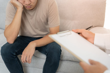 man with mental health problems is consulting. psychiatrist is recording the patient's condition for treatment. encouragement, love and family problem, bipolar , depression patient, protect suicideの写真素材