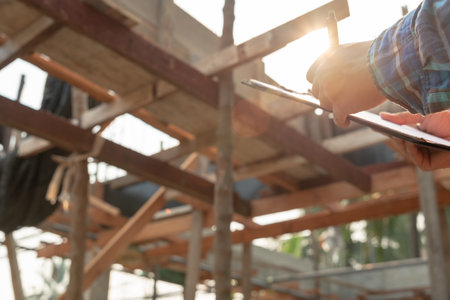 inspector or engineer is inspecting construction and quality assurance new house using a checklist. Engineers or architects or contactor work to build the house before handing it over to the homeownerの写真素材