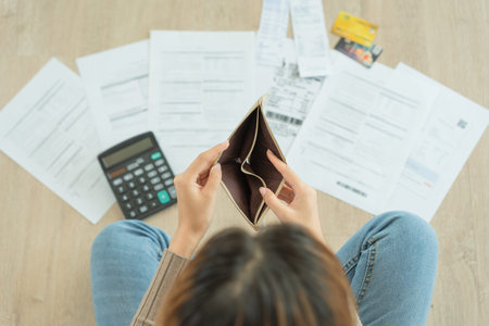 Stressed and headache woman with large bills or invoices no money to pay to expenses and credit card...