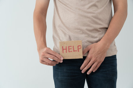 Man hold hand in front of private parts feeling discomfort from disease and inflammation. Venereal, testicular cancer. bladder problems, erectile dysfunction, premature ejaculation, prostate cancerの写真素材