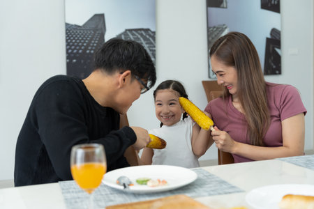 activities together during the holidays. Parents and children are having a meal together during the holidays. Mather prepare milk for dauther on morning, enjoy, weekend, vacant, family time, happy.の写真素材