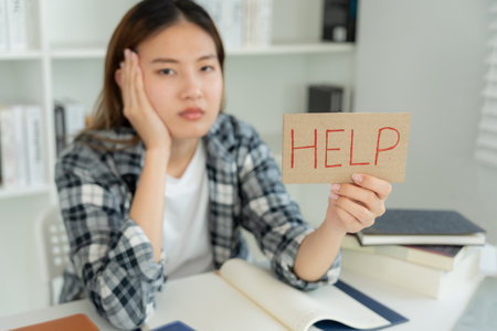 Asian student woman have anxiety because of exams, female prepare for test and learning lessons in the library. stress, despair, haste, misunderstanding reading, discouraged, expectation, knowledgeの写真素材
