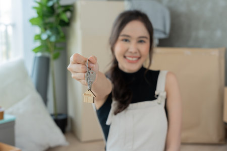 Moving house, relocation. Woman hold key house keychain in new house. move in new home. Buy or rent real estate. flat tenancy, leasehold property, new landlord, dwelling, loan, mortgage.の写真素材