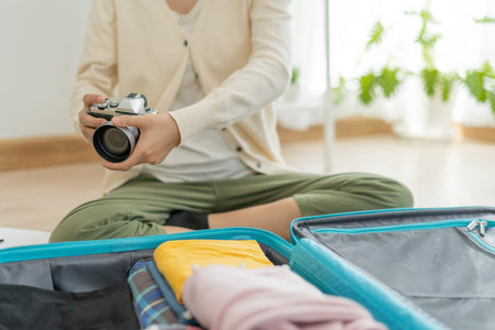Traveler. female is preparing a camera for travel and photography. women are prepare clothes and...