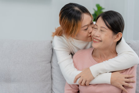 Mother day, cute asian teen girl hugging and kissing on the cheek, mature middle age mum. Love, kiss, care, happy smile enjoy family time. celebrate special occasion, happy birthday, merry Christmas.の写真素材