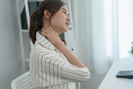 office syndromes, woman massaging neck pain due to work and using a computer, digital composite of a focused spine of neck pain and shoulder pain symptoms , injuries, health care, medical, myositisの写真素材