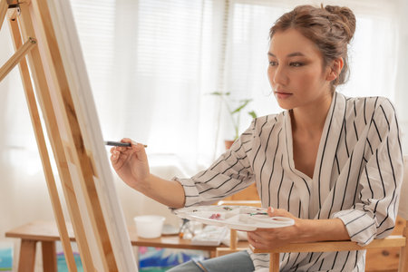 Professional female artist girl use paintbrush in abstract art for create masterpiece. painter paint with watercolors or oil in studio house. beautiful woman enjoy painting as hobby. work recreationの写真素材