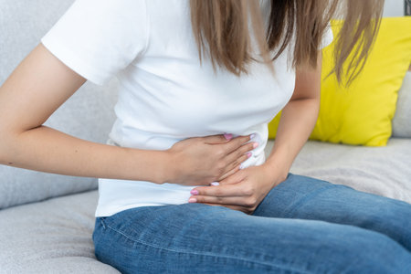 stomach ache. Asian women have abdominal pain, indigestion, gastritis, menstrual cramps, flatulence, diarrhea, distention, colon cancer, belly inflammation problem, suffer food poisoning, abdomenの写真素材