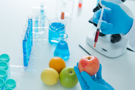 Scientist check chemical food residues in laboratory. Control experts inspect quality of fruit, scientists inject chemicals into apples for experiments, hazards, prohibited substance, contaminateの写真素材
